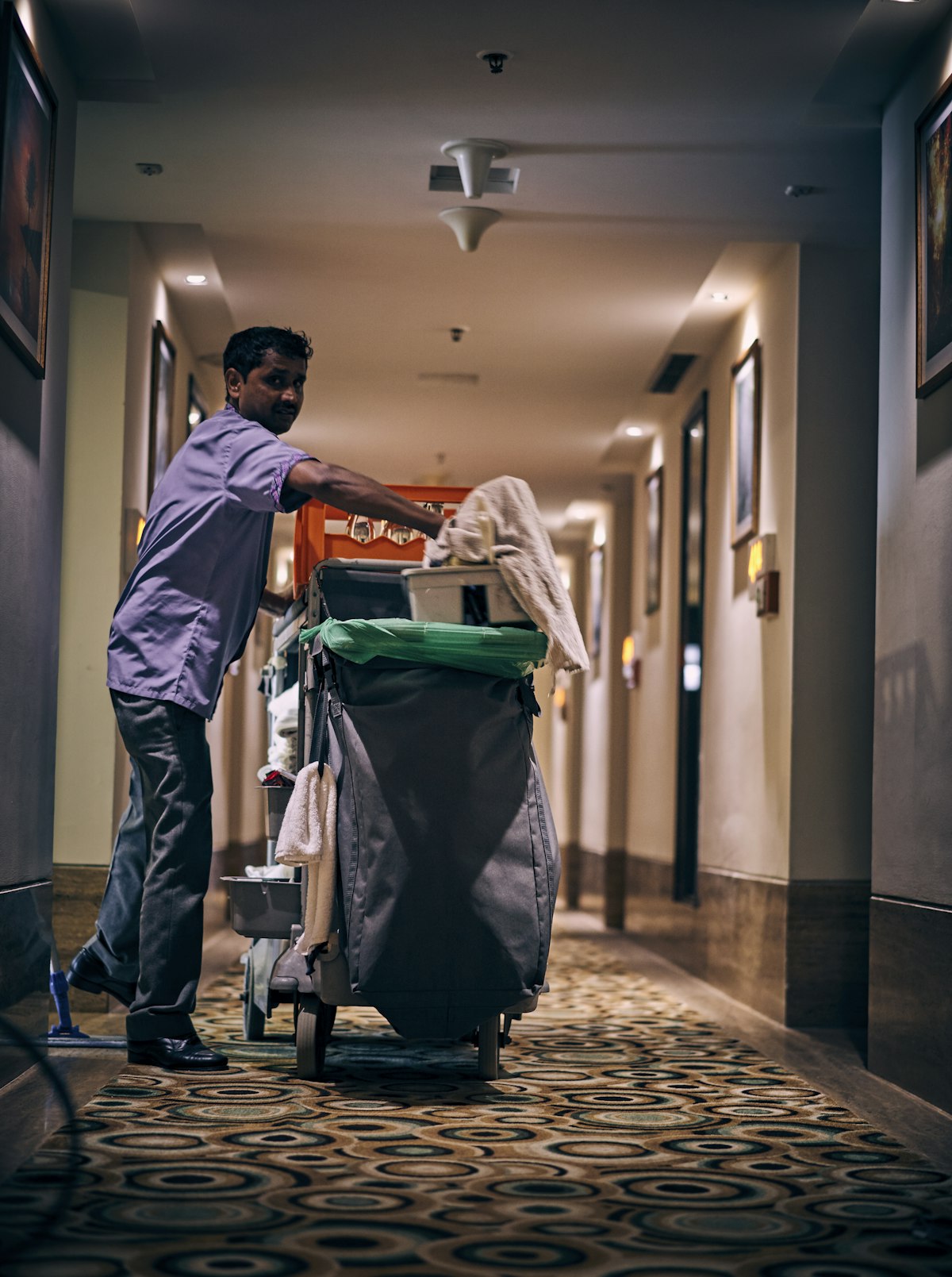 Levone cleaning professional with a janitorial cart in a commercial hallway